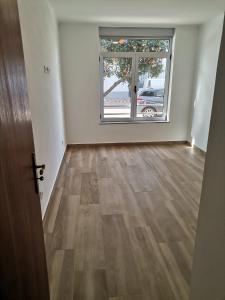 una stanza vuota con una grande finestra e pavimenti in legno di Casa Rainha Santa a Estremoz