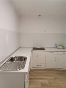 una cucina con lavandino e piano di lavoro bianco di Casa Rainha Santa a Estremoz