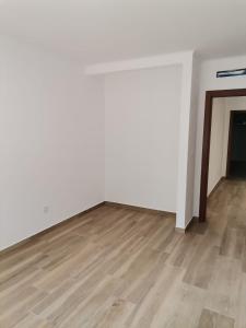 una stanza vuota con pareti bianche e pavimenti in legno di Casa Rainha Santa a Estremoz Altre 2 foto