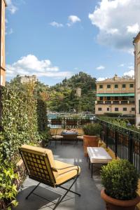 a patio with chairs and tables on a balcony at Splendido Mare, A Belmond Hotel, Portofino in Portofino