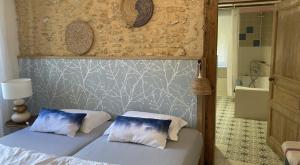 a bedroom with a bed with two pillows and a bathroom at Les Orchidées - Chambre in Puyvendran
