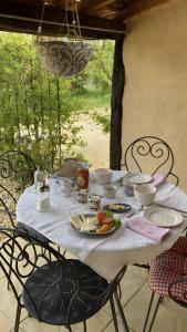 a table with a white table cloth with food on it at Les Orchidées - Chambre in Puyvendran