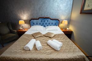 a bedroom with a bed with two pillows and towels at Hotel Belvedere in Predeal +38 photos