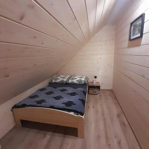 un letto in una stanza con soffitto in legno di Orkiszówka a Szczawnica Altre 29 foto