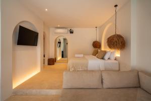 een slaapkamer met een bed en een bank bij Luna Kai Villas in Uluwatu