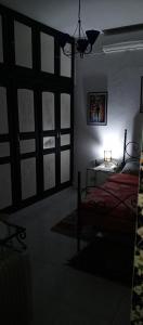 een slaapkamer met een bed en een tafel met een lamp bij Dar Fawaz in Tunis