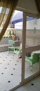 een patio met 2 groene stoelen en een tafel bij Dar Fawaz in Tunis
