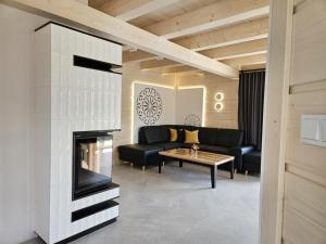 a living room with a couch and a fireplace at Anielskie chaty - domki z widokiem na góry in Sablówka