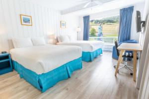 a hotel room with two beds and a window at Riotel Perce in Perce