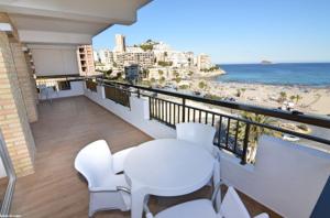 balcone con tavolo, sedie e spiaggia di Apartamentos Odysea By Apartamentos Valentia a Cala de Finestrat