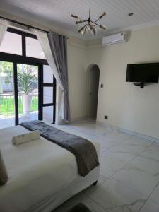 彼得马里茨堡The Corner Guesthouse的一间卧室，里面有一张床和一个吊扇