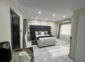 彼得马里茨堡The Corner Guesthouse的房间里有一张床和一张桌子的卧室