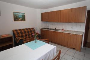 a kitchen with a table and a couch in a room at Apartments Duomo in Cres