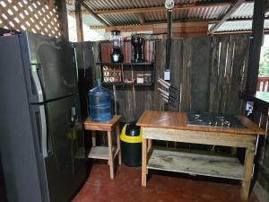 a kitchen with a wooden table and a refrigerator at Rustik Cabaña in Lanquín
