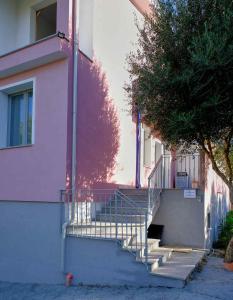 un bâtiment avec des escaliers à côté d'un bâtiment avec un arbre dans l'établissement Le Magie di Gioba, à Chia