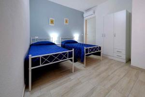 - 2 lits dans une chambre avec des draps bleus dans l'établissement Le Magie di Gioba, à Chia