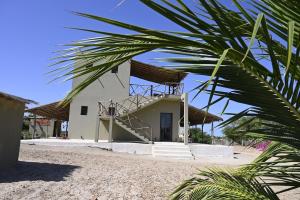ein Gebäude mit Strohdach und einer Treppe in der Unterkunft Villa Palmarin Plage&Piscine in Palmarin