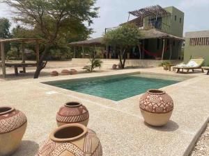 ein Swimmingpool mit Vasen auf einer Terrasse in der Unterkunft Villa Palmarin Plage&Piscine in Palmarin