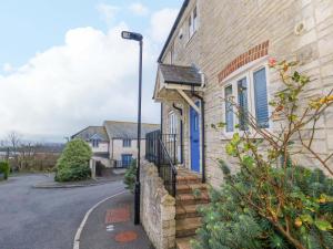 a house with a blue door on a street at Ash Corner Cottage in Weymouth