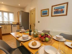 a dining room table with a bowl of fruit on it at Ash Corner Cottage in Weymouth