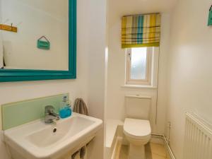 a bathroom with a white sink and a toilet at Ash Corner Cottage in Weymouth +23 photos