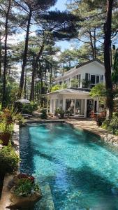 a swimming pool in front of a house at Tiên Hoa Sơn Villa in Da Lat