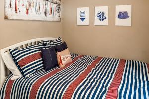 a bed with a striped comforter and two pillows at Cherry Fish North in Beulah