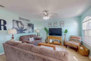 a living room with a couch and a flat screen tv at Paradise in the Palms in Mexico Beach