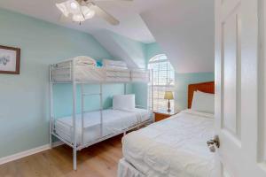 a bedroom with two bunk beds and a ceiling fan at Paradise in the Palms in Mexico Beach +23 photos
