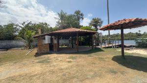a gazebo on the beach next to the water at NLC locações BonsVentos in Barreirinhas