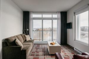 a living room with a couch and a large window at Riotel Matane in Matane