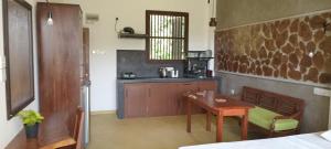 een keuken met een houten tafel en een kleine tafel en een tafel bij Guruwaththa Eco Villa 3 in Hikkaduwa +25 foto's