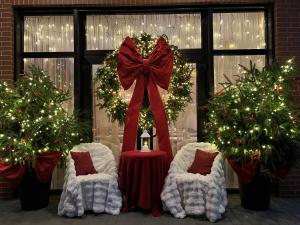 帕兰加Labas Rytas Vila的房间里有两把椅子、一张桌子和几棵圣诞树。