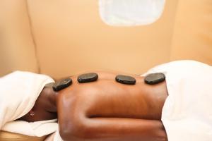 a man laying in a bed with twoippers on his stomach at Pristine Mara Bay Lodge in Masai Mara