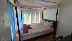 una camera con letto a baldacchino e finestra di COCO JAMBO PARADISE Resort a Uroa