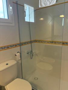 ein Badezimmer mit Toilette und Glasdusche in der Unterkunft Villa Blanc in Sa Caleta + 13 Fotos