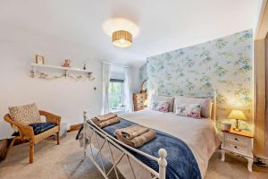 een slaapkamer met een bed en een stoel bij 3 Bed in Machynlleth oc-bow43 in Corris