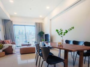 a living room with a wooden table and chairs at The Levana Home Saigon in Ho Chi Minh City