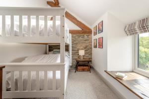 a bedroom with a white bunk bed and a window at 3 Bed in Machynlleth oc-bow40 in Darowen