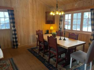 a dining room with a wooden table and chairs at Nostalgic Cabin With 3 Br, Fireplace, And Terrace in Beitostøl