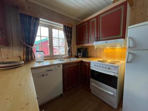 a kitchen with a white stove and a refrigerator at Nostalgic Cabin With 3 Br, Fireplace, And Terrace in Beitostøl