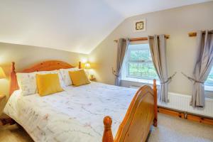 a bedroom with a wooden bed and a window at 2 Bed in Betws-y-Coed oc-84026 in Penmachno