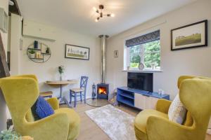 een woonkamer met gele stoelen en een open haard bij 3 Bed in Letheringham oc-pclet in Kettleburgh