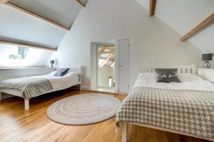 een slaapkamer op zolder met 2 bedden en een tapijt bij 4 Bed in Drewsteignton oc-bc2408 in Drewsteignton