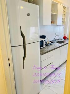 Ein weißer Kühlschrank in einer Küche mit Schriftzeichen auf dem Boden in der Unterkunft Depto Colón y viamonte in Mar del Plata + 4 Fotos
