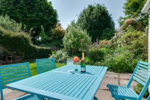 un tavolo blu con due sedie e una bottiglia di vino di 3 Bed in Hindringham oc-861 a Hindringham