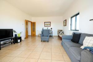 un soggiorno con un divano blu e una TV di B80 - Gideon Albasol 2 Bed Apartment in Lagos a Lagos