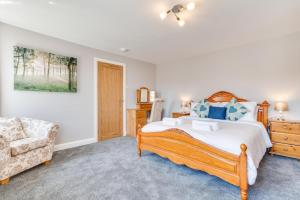 um quarto com uma cama grande e uma cadeira em 2 Bed in Fowey oc-jackda em Fowey