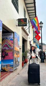 una mujer caminando por una calle con una maleta en Hotel el Conquistador, en Cusco