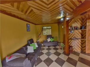 een woonkamer met een bank en een houten plafond bij Hotel Don Taco in Monteverde Costa Rica